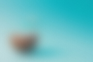 Softly blurred heart shape on a serene aqua background, symbolizing love and tenderness.