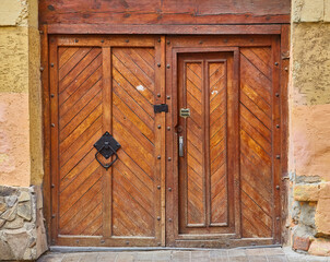 Ancient rustic wooden gate with forged iron hardware.