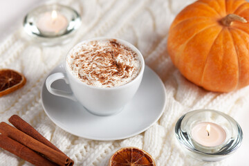 Warm Pumpkin Spice Latte with Candles and Cinnamon