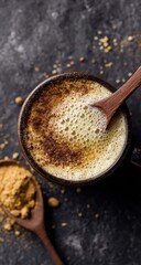 A warm, creamy drink with a rich, spiced topping sits on a dark surface, showcasing the vibrant flavors and textures.