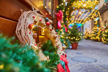 Rustic handmade Christmas wreath with glowing lights at a holiday market.