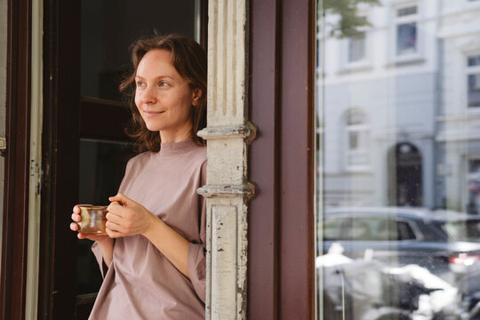 Creative entrepreneur enjoying break in urban studio with ceramic cup
