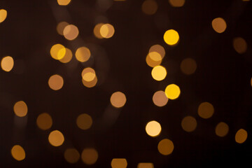 Lots of unfocused golden Christmas lights on a dark background