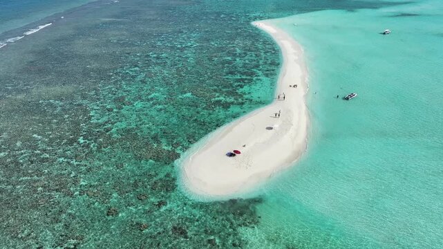 Aerial view of a pristine white sandbank surrounded by turquoise waters, with boats and people scattered across the scene, Thoddoo, Alif Alif Atoll, Maldives.