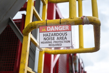 High noise working area warning, required to wear hearing protection. The safety sign at industrial refinery process plant. 