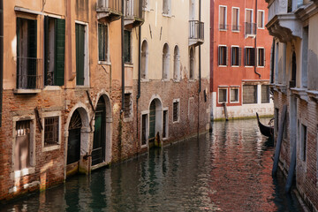 Picturesque Venice canal framed by colorful old houses and the timeless presence of a gondola in the distance