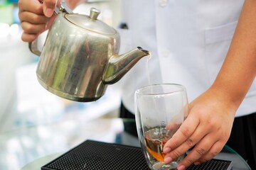 Pouring herbal tea into a tea glass