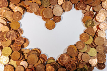 Euro cent coins arranged around an empty heart shaped space, symbolizing love, money, finance, and...