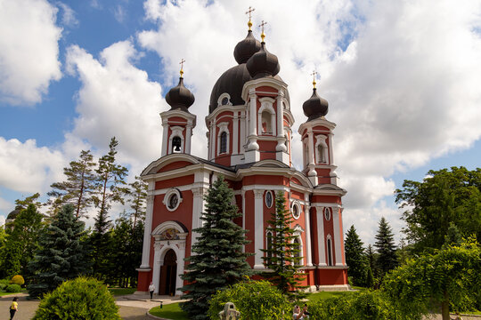 Curchi Monastery in Moldova features a striking red and white striped facade with intricate architectural details. Ideal for themes on culture, travel, history, tourism, religion, Eastern Europe