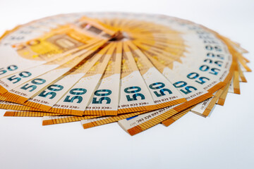 Circular arrangement of 50 euro banknotes fanned out in a complete ring on a white background,...