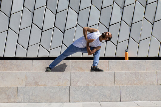 Runner doing morning yoga and stretching outdoors in Lisbon by MAAT