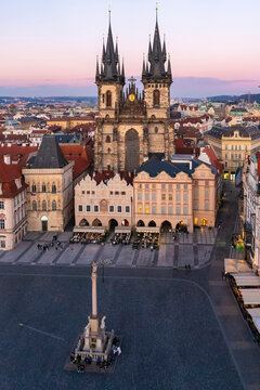 Aerial view of the old town square with the National Gallery and The Church of Our Lady before Tyn in Prague, Czech Republic during sunset blue hour.