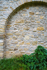 old stone wall with arch create a frame with blank space, close up of beautiful and cozy architectural details