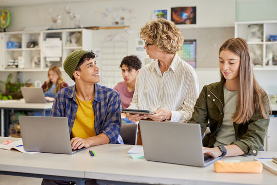 Multiethnic students using laptop during computer class