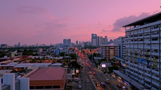Aerial view of a cityscape with a long road, buildings, and a pink sky, showcasing the urban landscape, Cebu City, Central Visayas, Philippines.