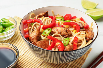 Delicious noodles with meat and vegetables served on white table, closeup