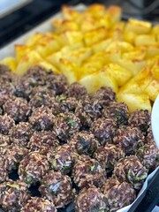Baked meatballs and potatoes on a tray, perfect for home-cooked meal background
