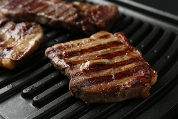 Electric grill with delicious beef meat, closeup
