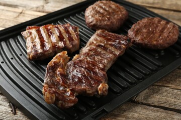 Delicious grilled beef meat on wooden table, closeup