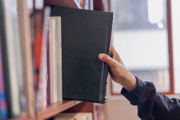 hand taking binder from bookshelf in office library. Concept of business organization, document management, archive, education, and knowledge storage.