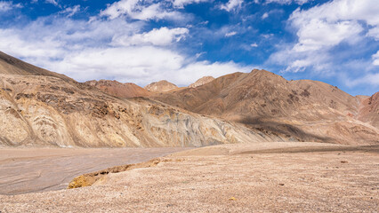 Barren high altitude mountain landscape with dry river bed along Pamir Highway aka M41, Murghab, Gorno-Badakhshan, Tajikistan