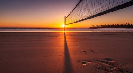 Beach volleyball net at sunset with golden sky and ocean waves in tropical paradise