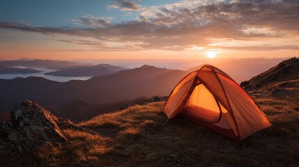 Scenic camping adventure: A tent glows against the backdrop of a mountain sunrise