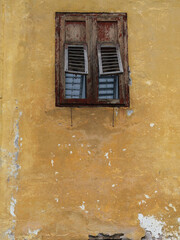 An Old Rustic Wooden Window On A Yellow Wall