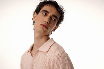 Stylish man showcasing elegant fashion in soft pastel attire during a minimalist photo shoot