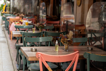 Wooden tables surrounded by vibrant pink and blue chairs in outdoor cafe, capturing a lively and inviting atmosphere, perfect for dining, hospitality, cafes, restaurants, lifestyle and outdoor leisure
