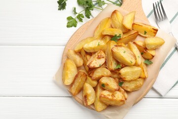 Tasty baked potatoes with parsley on white wooden table, flat lay. Space for text