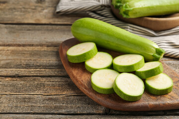 Fresh ripe zucchinis on wooden table, space for text. Whole and cut