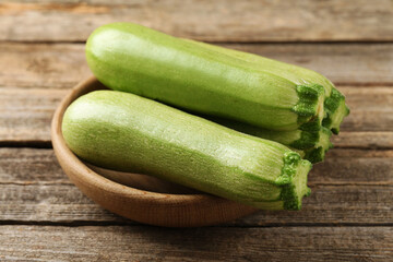 Fresh ripe zucchinis on wooden table, closeup