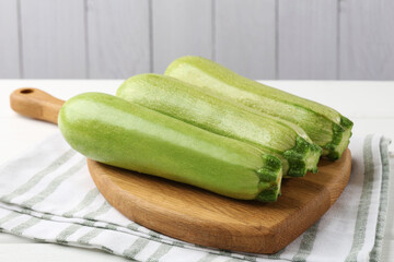 Fresh ripe zucchinis on white wooden table, closeup