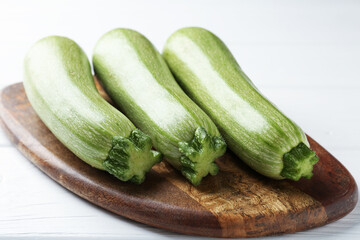 Fresh ripe zucchinis on white wooden table, closeup