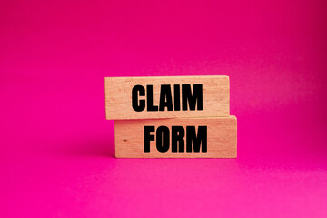 Claim Form message written on wooden blocks on pink background. Conceptual Claim Form symbol. Copy space.