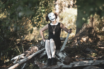 Masked schoolgirl in forest sitting quietly on autumn tree.