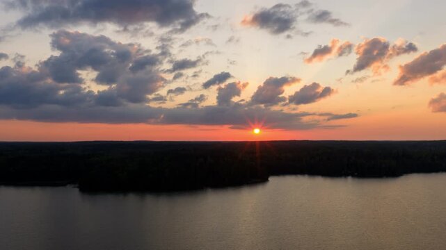 Hyperlapse drone shot of a dramatic sunset with clouds above Lake Bodom, Espoo