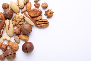 Mix of different nuts on white background, flat lay. Space for text