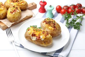 Tasty stuffed baked potatoes served on white wooden table