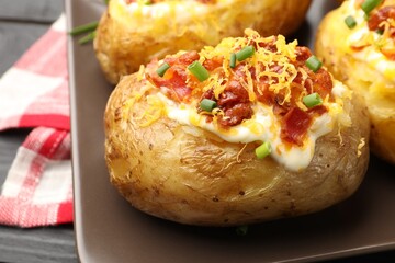Tasty stuffed baked potatoes on black table, closeup