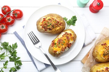 Tasty stuffed baked potatoes served on white wooden table, flat lay
