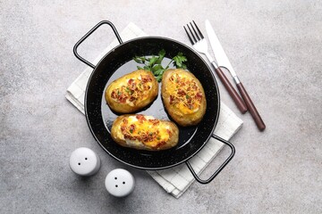 Tasty stuffed baked potatoes served on grey table, flat lay