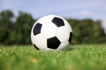 Soccer ball on green grass outdoors. Football game