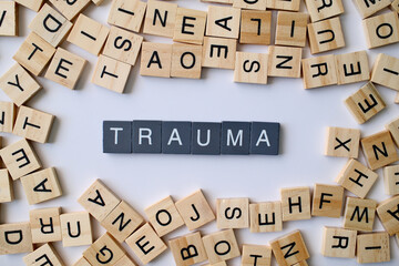 Trauma word in wooden cube blocks, psychological stress concept, emotional injury and mental health idea, recovery and therapy theme