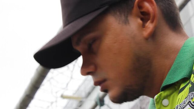 Portrait of a young Latino instructor calling his students' attendance before a soccer training session inside a sports center in Neiva, Huila, Colombia. Concept of work