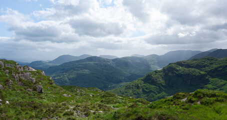 Overlook of lush green mountains in the Gap of Dunloe, County Kerry, Ireland.