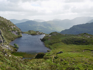 High-angle view of a tranquil mountain lake surrounded by rugged landscape.