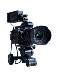 Professional cinema camera with large lens, mounted on a compact tripod, featuring an external recorder and various controls