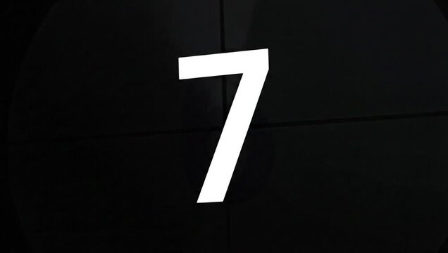 Close-up of a large white number seven on a black background